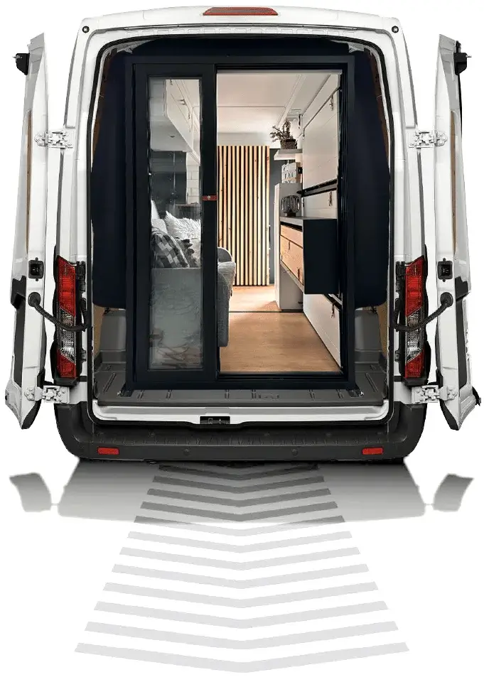 confortablement installée dans le coffre de sa voiture transformée en mini-van avec un kit d'aménagement pour le camping.