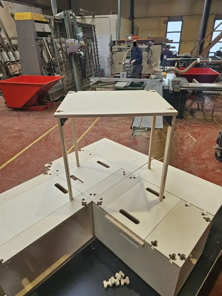 Vue de dessus d'un ensemble de modules d'aménagement en bois formant une surface plane, prêts à être installés dans un fourgon.